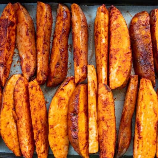 raw smoked paprika sweet potatoes laying on a baking tray