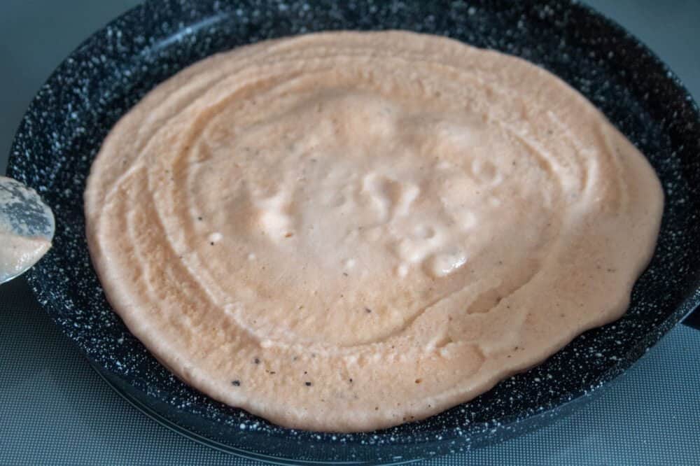 lentil wrap mixture in the frying pan with a spoon on the side