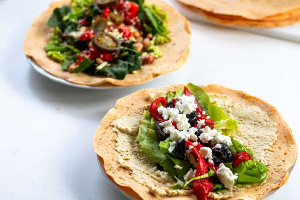 2 lentil wraps open on a plate with different fillings