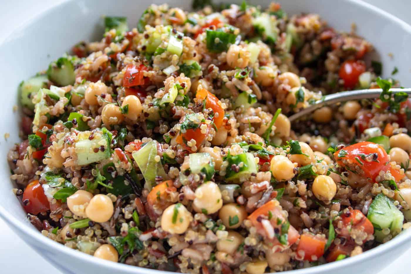 closeup of quinoa and brown rice salad in a bowl with a spoon