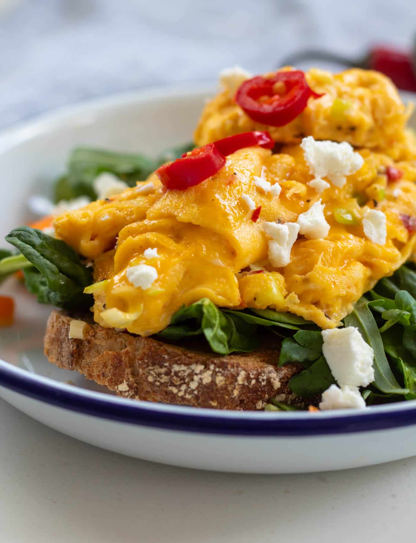 closeup of chili scramble served on top of toast and greens