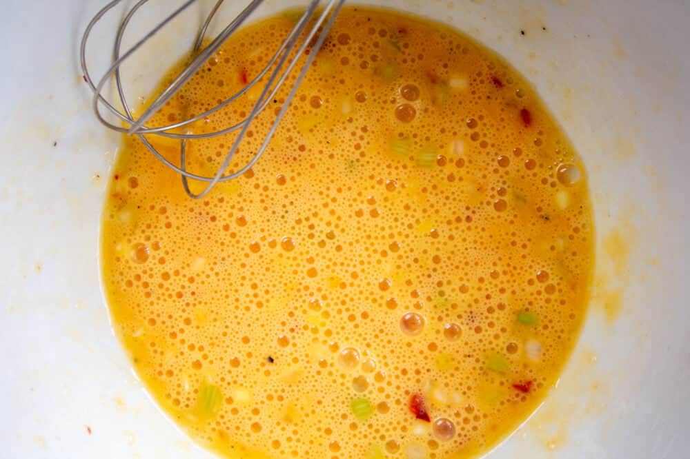 whisked eggs, chilli and spring onion in a bowl