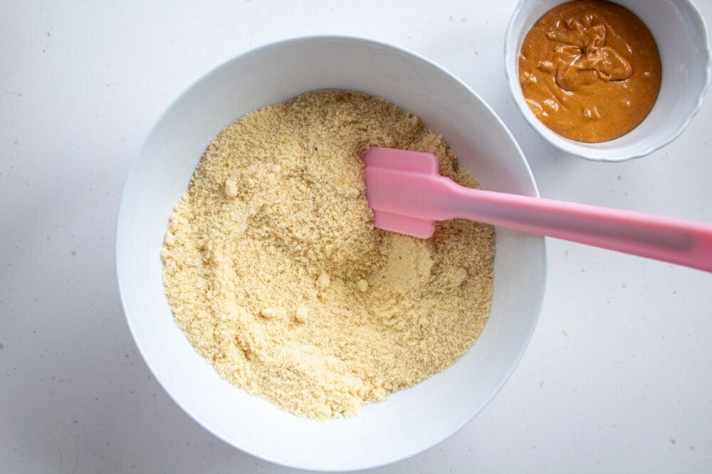 almond flour in a bowl with peanut butter in a separate bowl