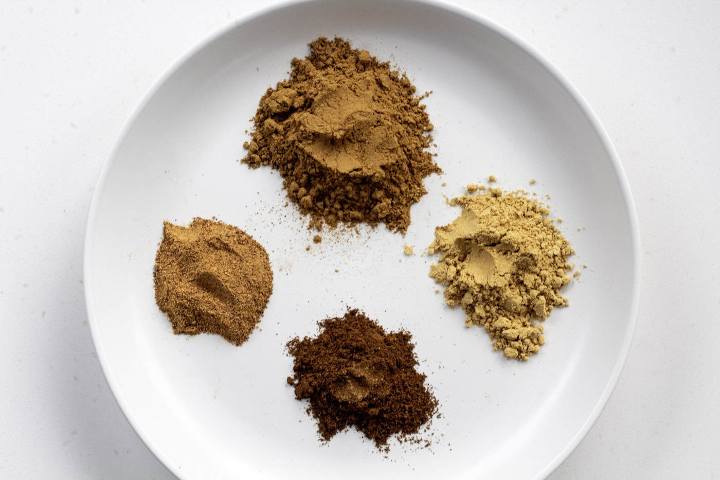 the 4 spices, cinnamon, ginger, ground cloves and nutmeg of a round plate