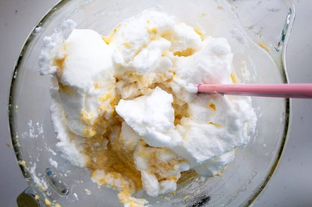 egg whites being mixed into the almond flour cake batter