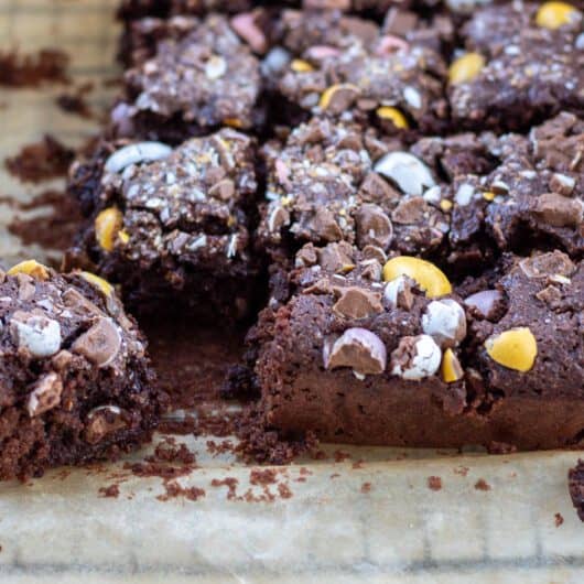 squares of low sugar chocolate easter brownie on parchment paper on a cooling rack