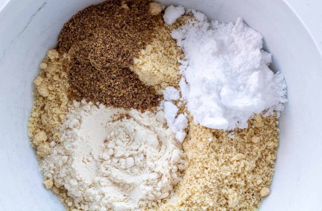 all the dry ingredients for the sugar free cheesecake base in a bowl including almond flour, flaxseed, coconut flour and powdered xylitol
