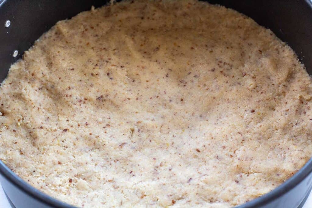 the almond flour base pressed into the cake tin