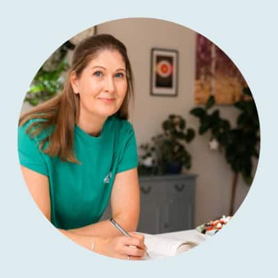 Michelle Rorke, founder of Whole Hearty Kitchen, smiling in her kitchen leanng on the counter - healthy food blogger UK