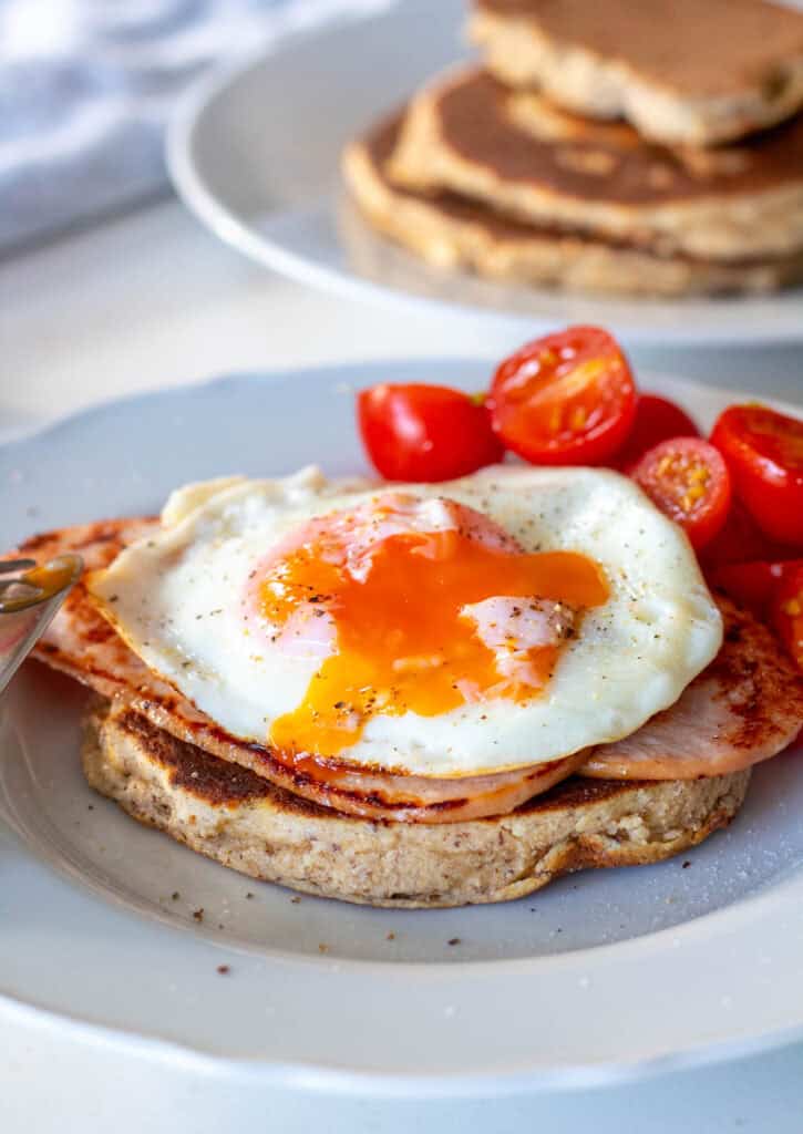 Savory almond flour pancakes topped with turkey bacon, fried egg and cherry tomatoes for a high-protein, diabetes-friendly breakfast.
