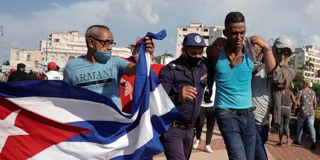 Police detain a person during protests against and in support of the government, amidst the coronavirus disease (COVID-19) outbreak, in Havana, Cuba July 11, 2021.