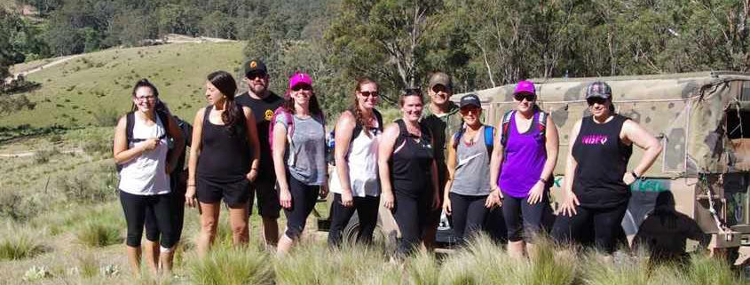 The Peak Potential Adventures group photo with Megalong Valley and the Blue Mountains in the distance as they trek along the Six Foot Track