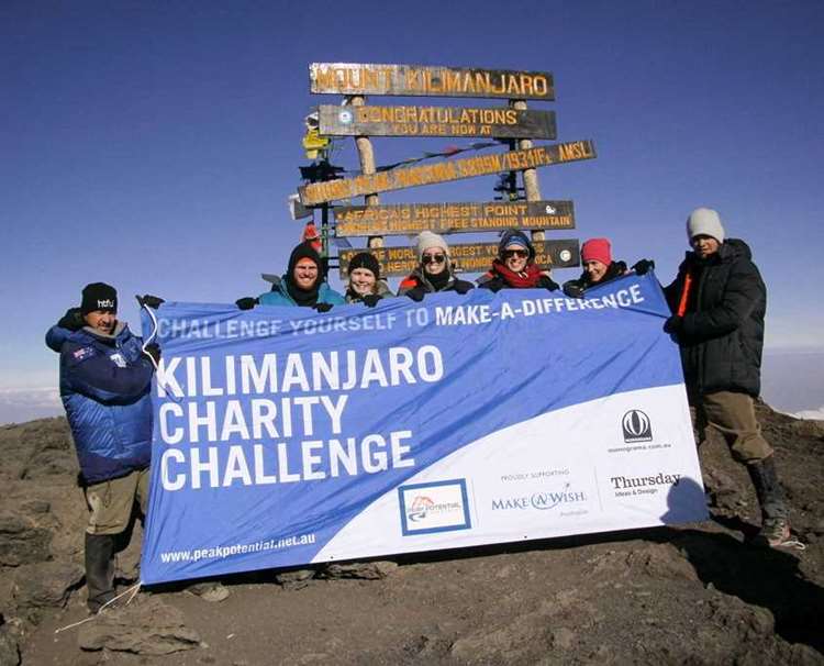 The team getting a summit photo on Mt Kilimanjaro in Africa