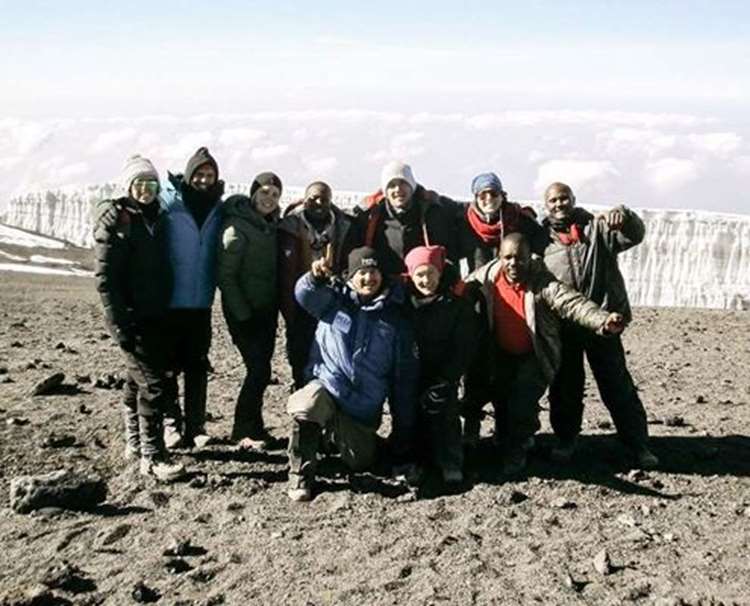 A photo of our team celebrating their summit success of Mt Kilimanajro in Africa