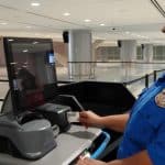 A TSA officer inspecting a passenger's ID