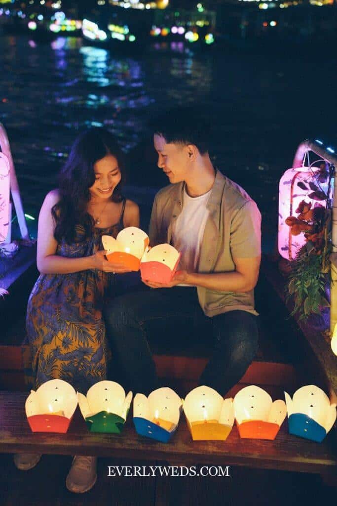 Couple holding colorful paper lanterns for budget outdoor wedding reception with romantic lighting and backyard decor ideas