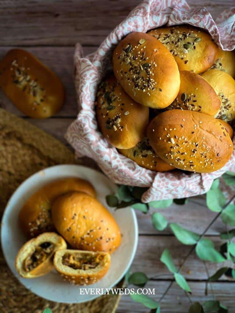 a bowl of sesame seed buns next to a plate of sesame seed buns