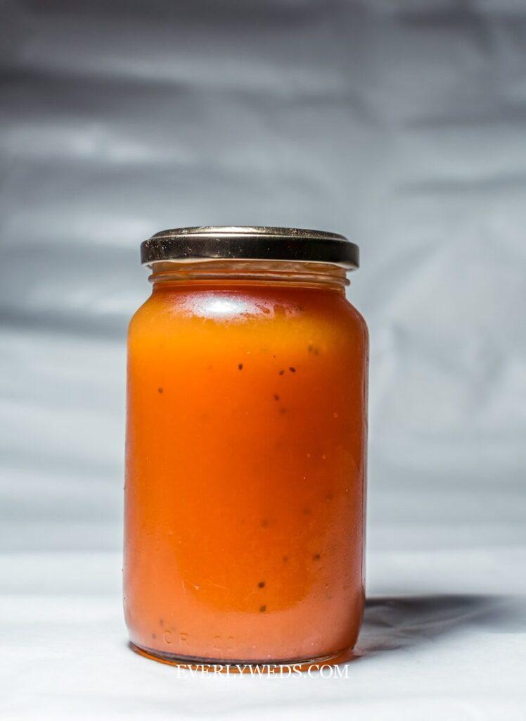 orange liquid in clear glass jar