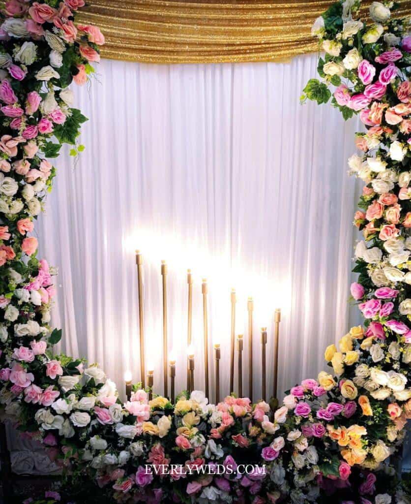 Stunning floral backdrop with candles - perfect low budget wedding decoration idea for outdoor ceremonies and receptions