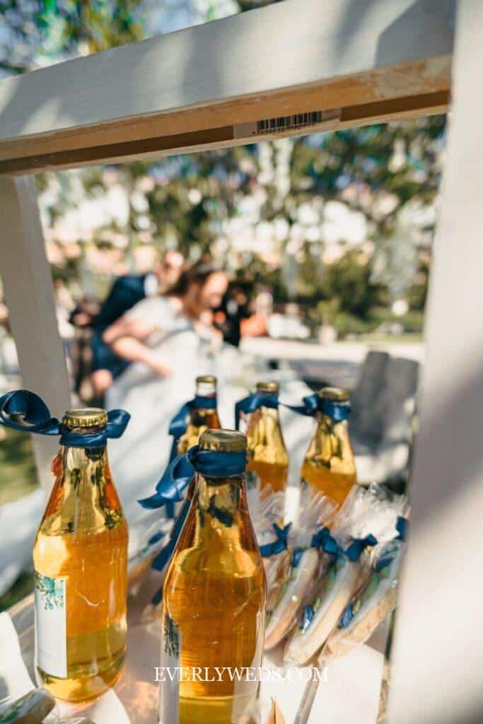 Bottles of drink and cookies decorated with blue ribbons.