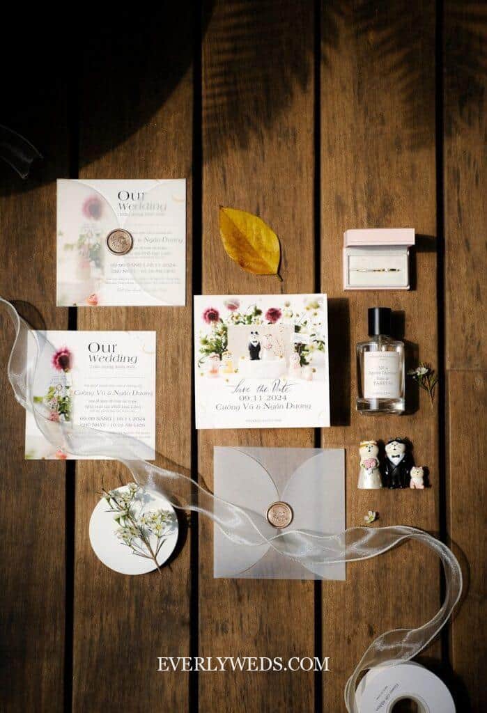 Elegant floral save the date cards with wedding rings and decorative elements on rustic wood background