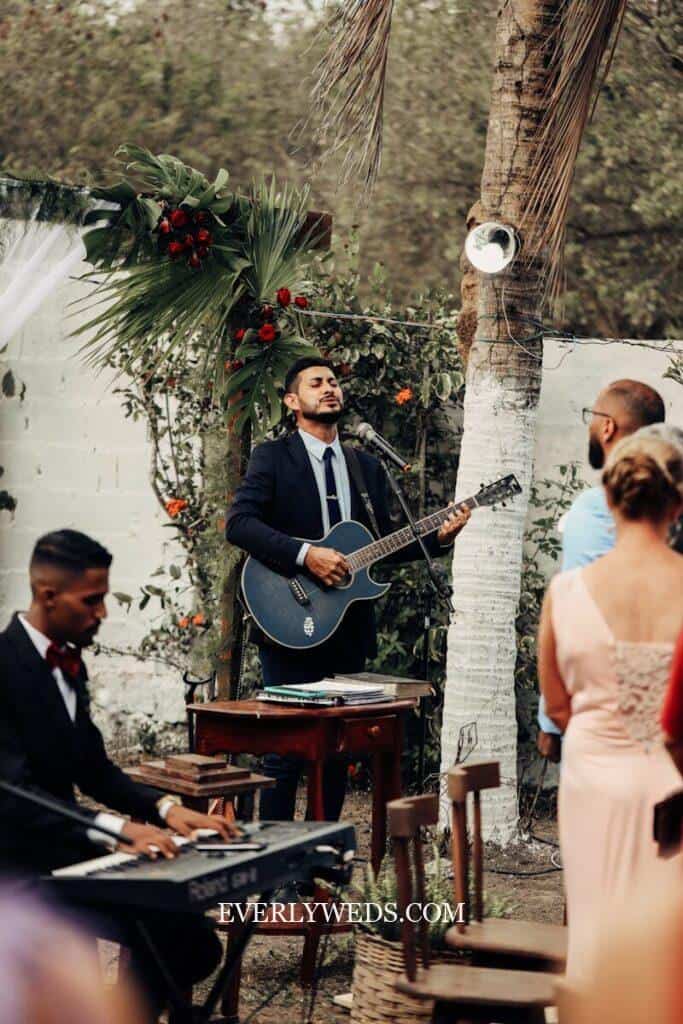a man playing a guitar in front of a group of people