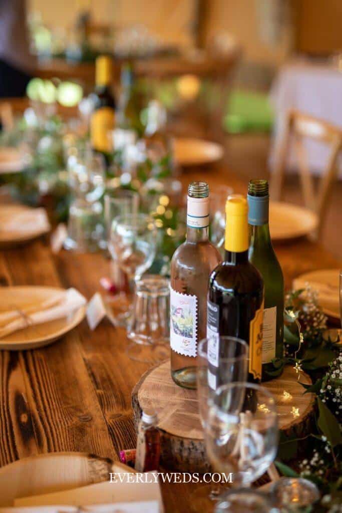 a wooden table topped with bottles of wine