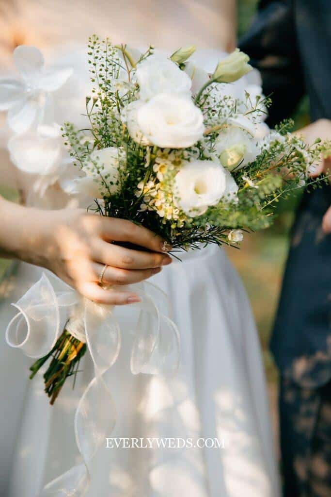 A close up of a person holding a bouquet of flowers