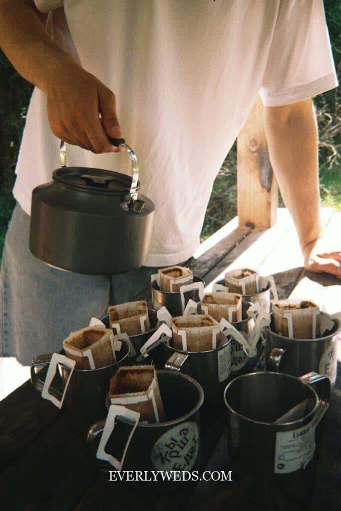 A man standing over a table filled with cups