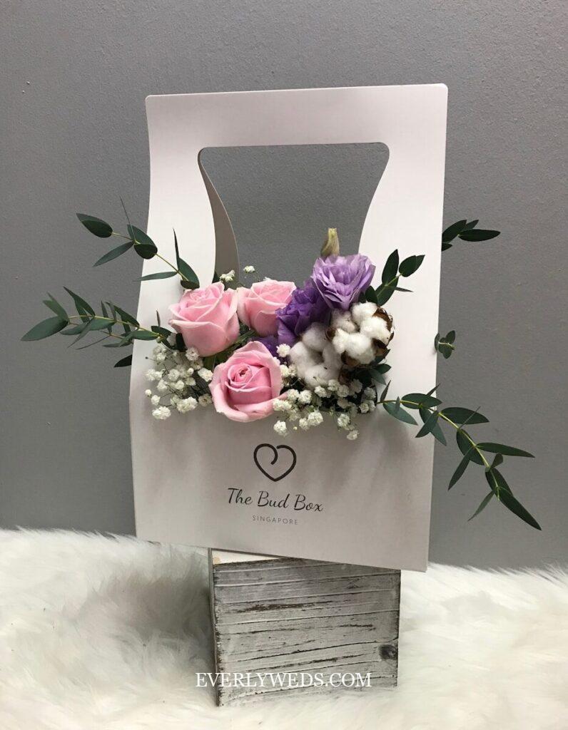 Creative wedding gift idea: elegant flower box with pink roses, purple blooms and greenery - perfect for couples of any age