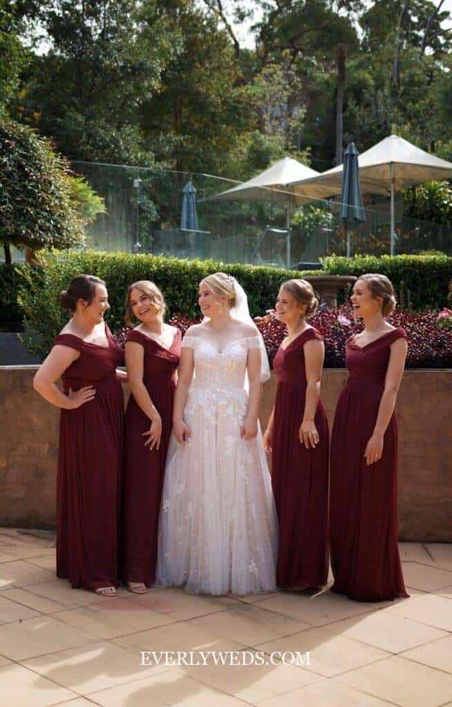 bridesmaids walking down aisle without bouquets holding hands naturally as minimalist modern wedding ceremony alternative