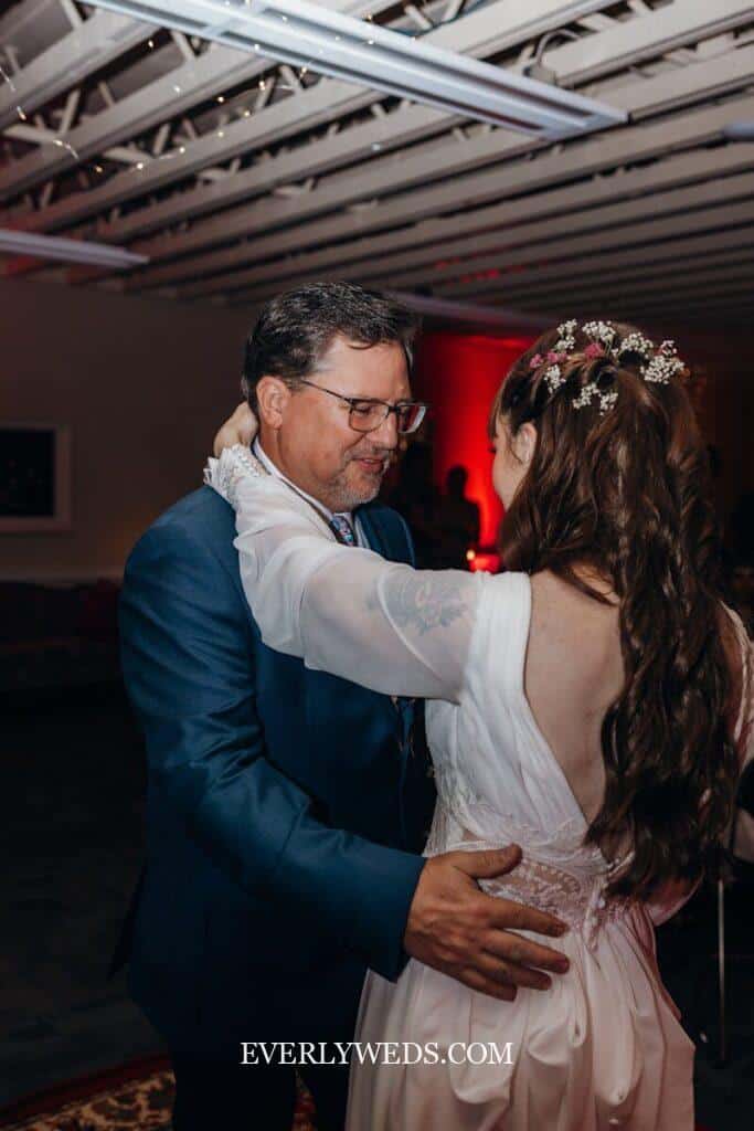 Stepdad dancing with bride at wedding reception emotional father figure dance