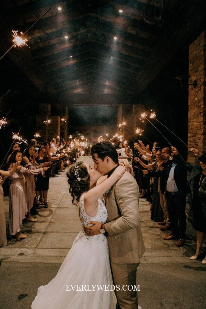 Romantic couple kissing at sparkler send-off wedding celebration - unique save the date ideas
