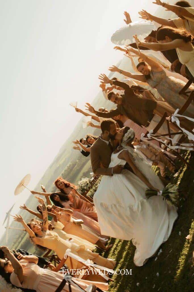 Bride and groom laughing during wedding ceremony exit to unexpected wedding recessional songs while bridal party cheers