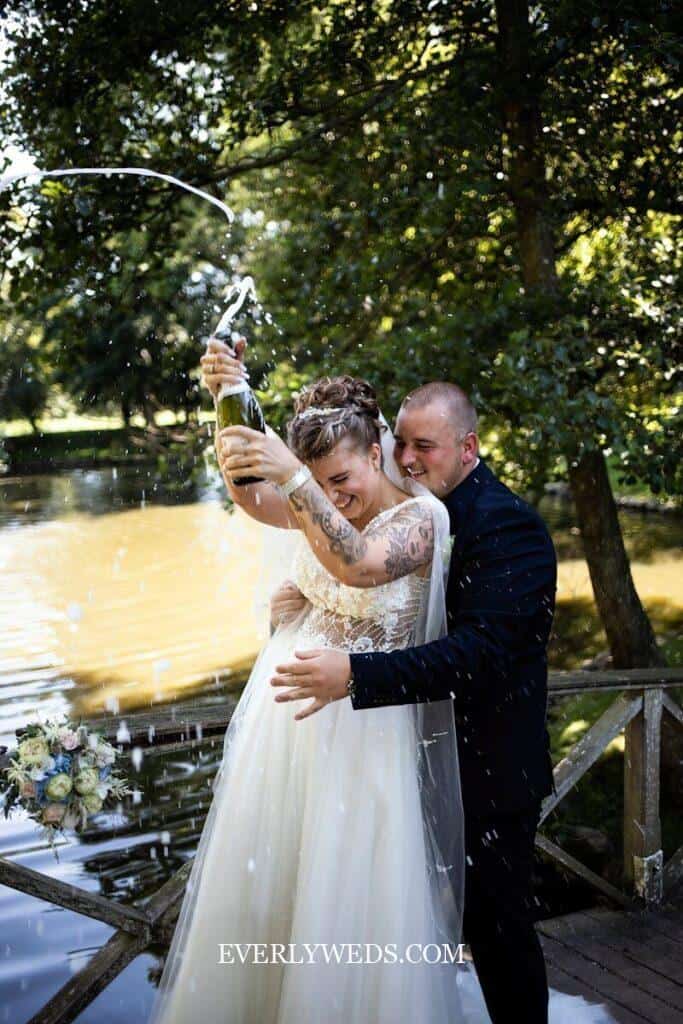 Couple celebrating with champagne spray - creative save the date ideas for weddings