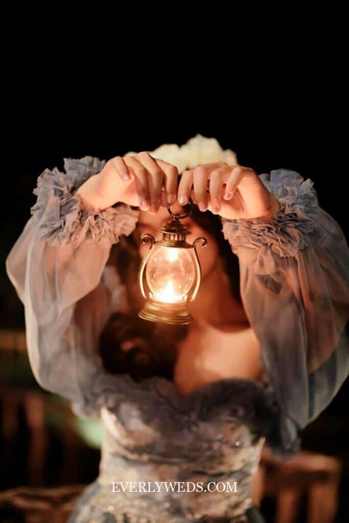bridesmaids carrying vintage lanterns with candles as unique bouquet alternative for evening wedding ceremony