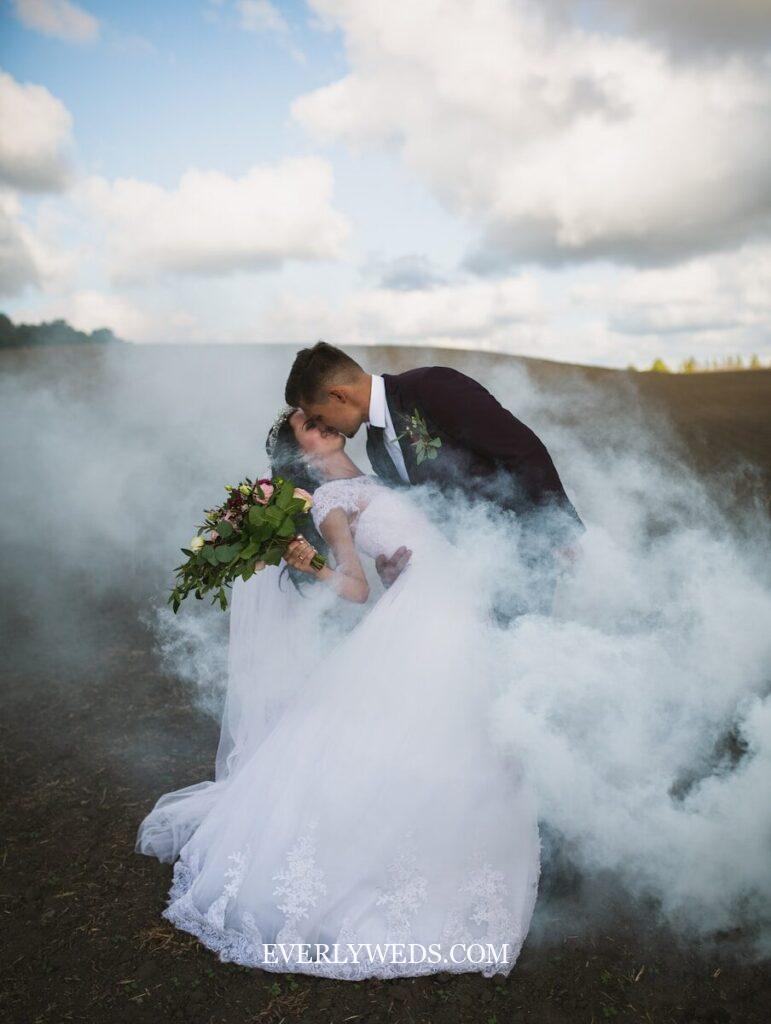 Romantic couple kissing in smoke for creative save the date photo inspiration ideas