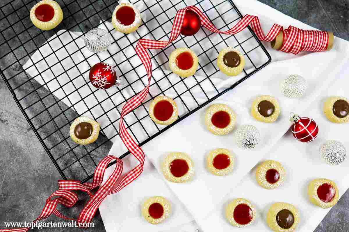 Foodblog_Topfgartenwelt_Husarenkrapfen_1 Leckere Husarenkrapfel teilweise gefüllt mit Nutella und Marmelade auf einem schwarzen Abkühlgitter.