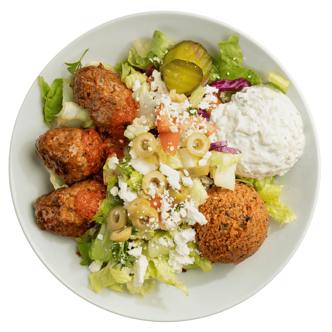 Salad bowl with lettuce, falafel, meatballs, olives, feta cheese, tzatziki, pickles, and diced tomatoes.