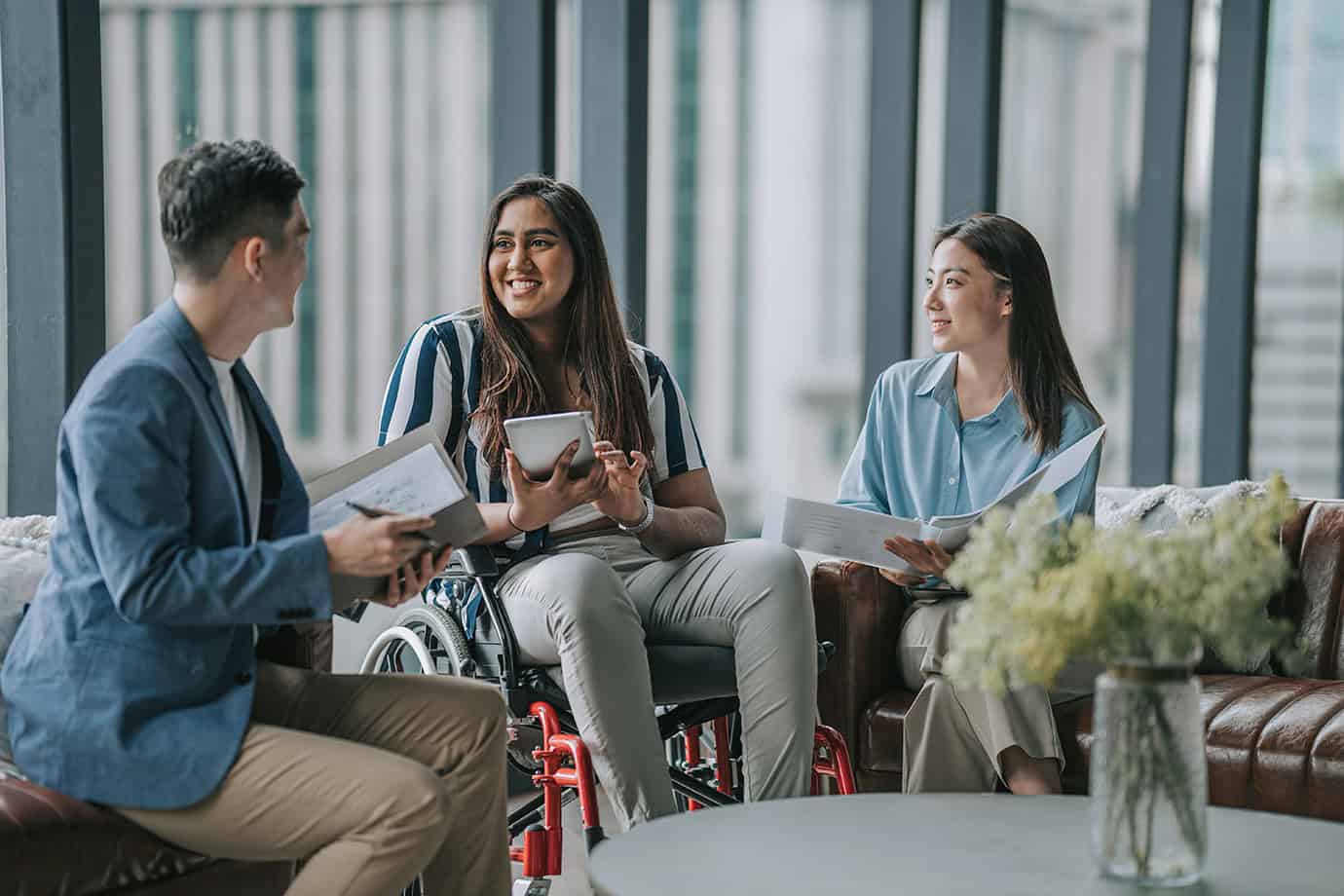 Woman in wheelchair talking to colleagues