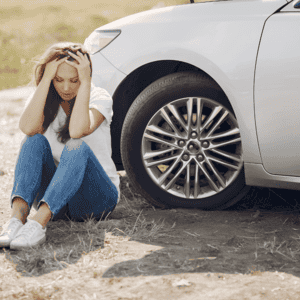 girl sits next to car in shock after automobile accident where friend dies due to wrongful death