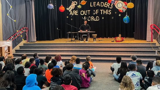 Ali Paris on stage for school assembly