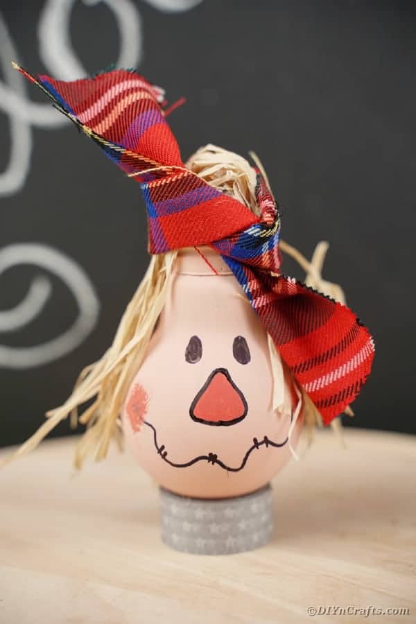 1. Adorable Upcycled Lightbulb Scarecrow Decoration
