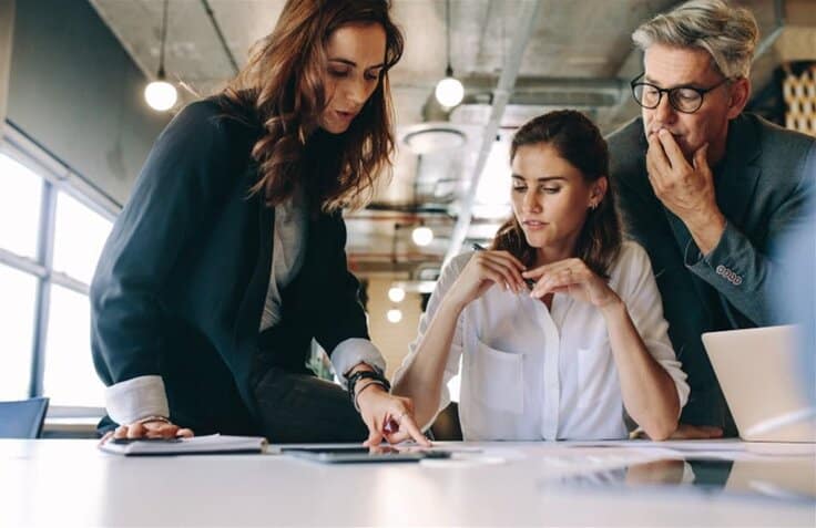 People discussing something while pointing on a document on the table