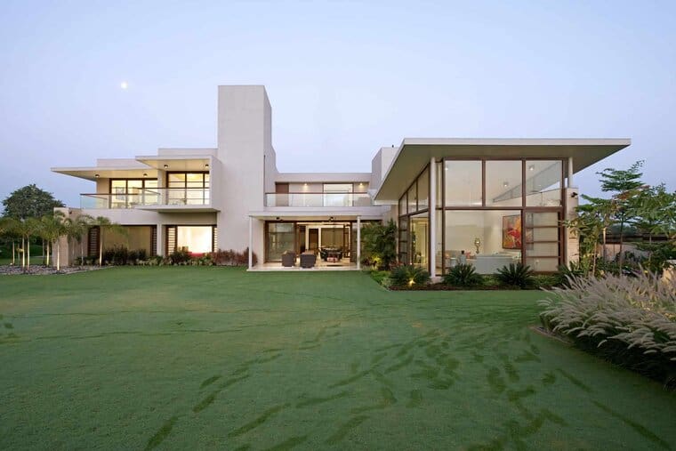 Modern luxury house with expansive glass windows and landscaped garden, showcasing contemporary architecture and smart home design.