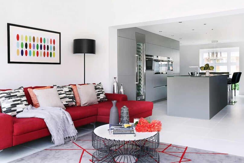 Modern minimalist kitchen and living room interior with colorful accents and contemporary furniture. Suitable for stylish apartment or home design ideas.
