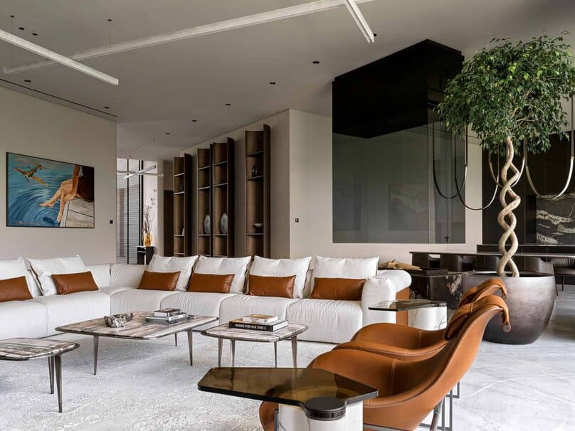 Contemporary living room with large white sofa, brown leather accents, and artwork.