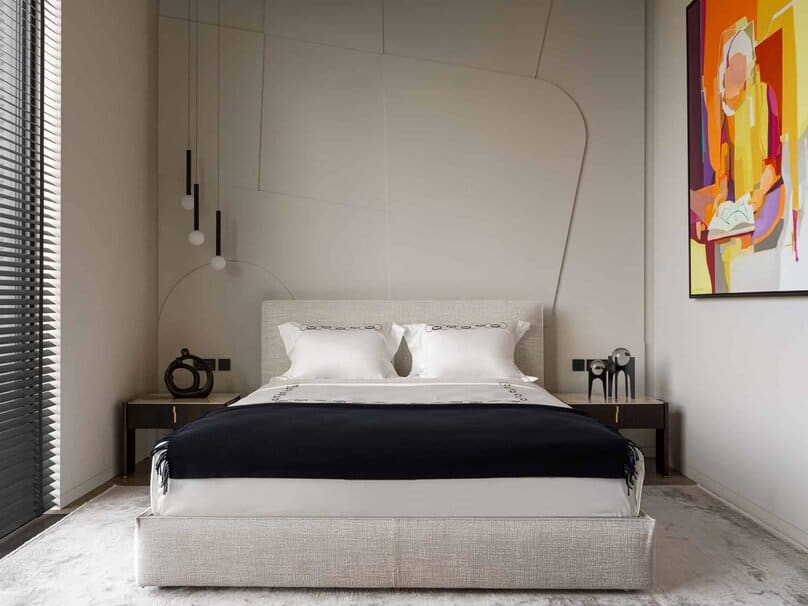 Modern bedroom with geometric wall patterns and a colorful abstract painting.