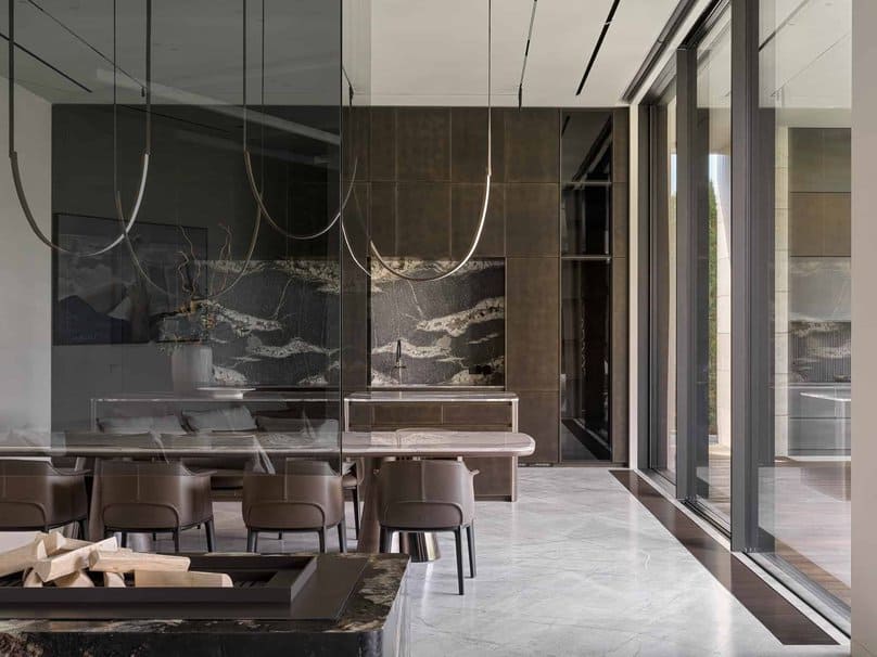 Reflective glass walls and marble kitchen in open dining space.