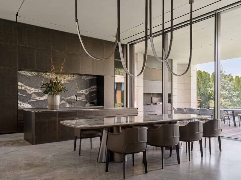 Large marble kitchen island and stylish dining table with pendant lights.